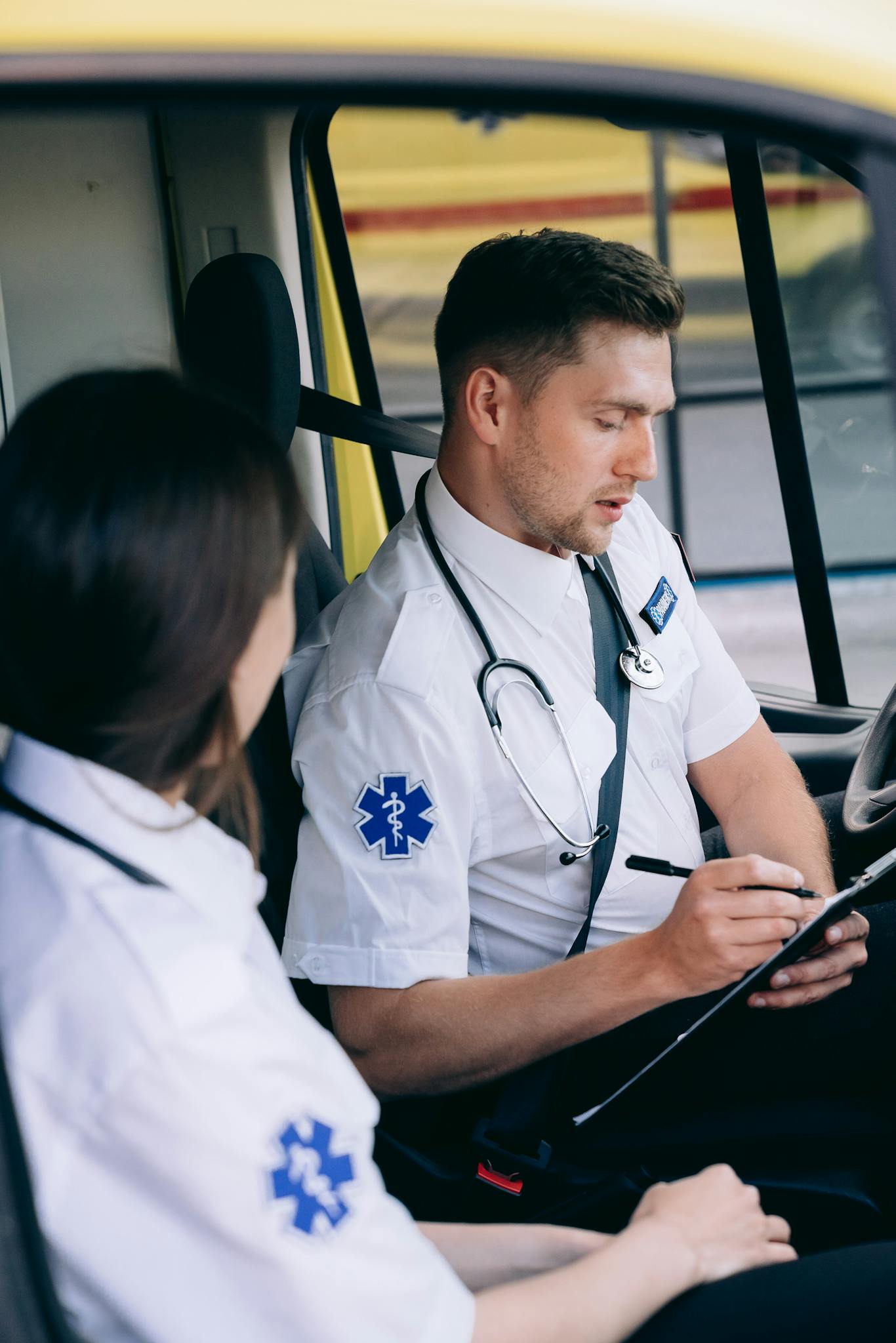 Paramedics in an ambulance reviewing notes during an emergency call.